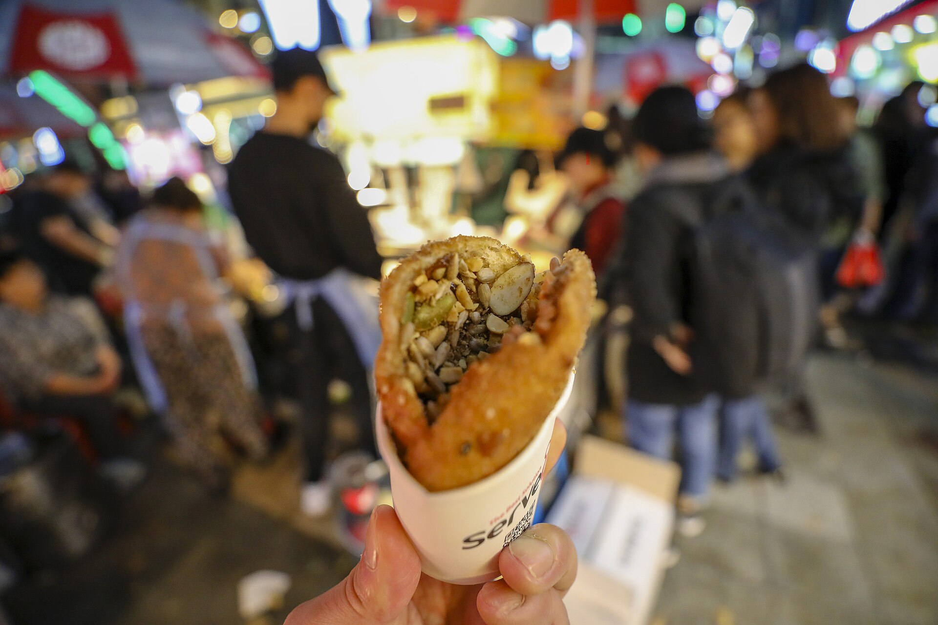 A ssiat-hotteok seed-stuffed sweet pancake being held open