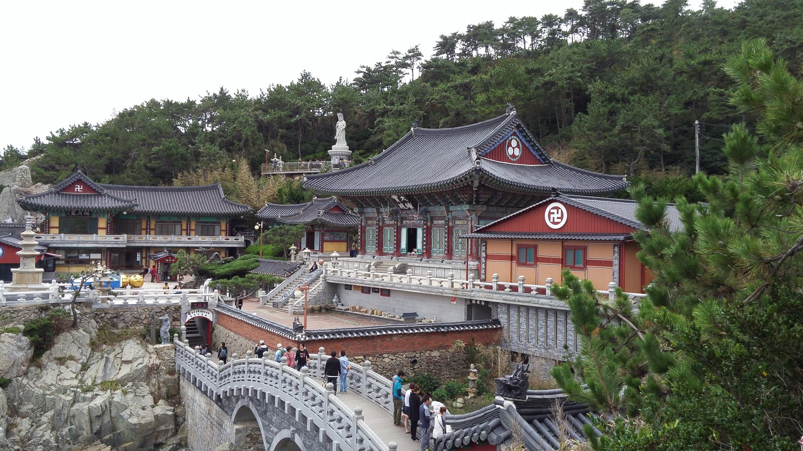 The ornate halls of Haedong Yonggungsa temple built into the coastal cliffs near Busan, reached by a stone bridge