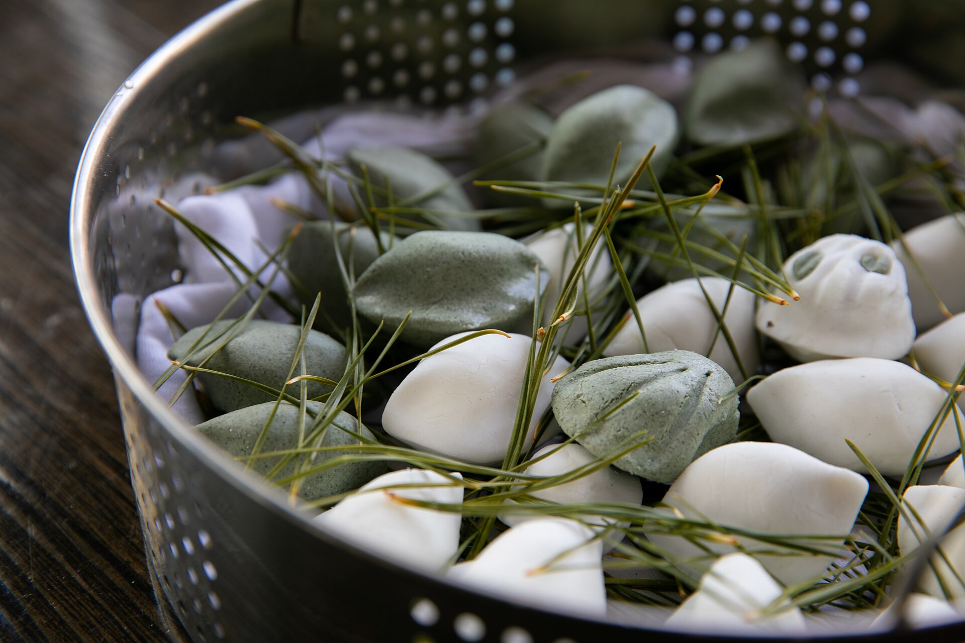 Freshly steamed songpyeon half-moon rice cakes with pine needles in a bamboo steamer
