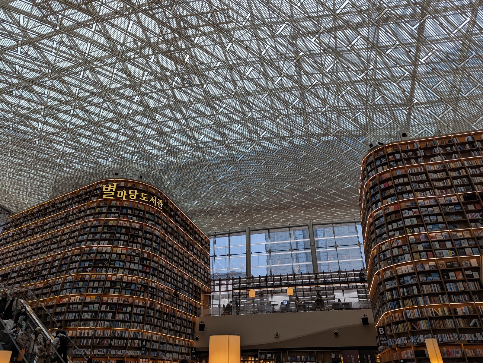 The Starfield Library inside COEX Mall — two towering 13-metre bookshelf walls under a bright atrium, with people reading below