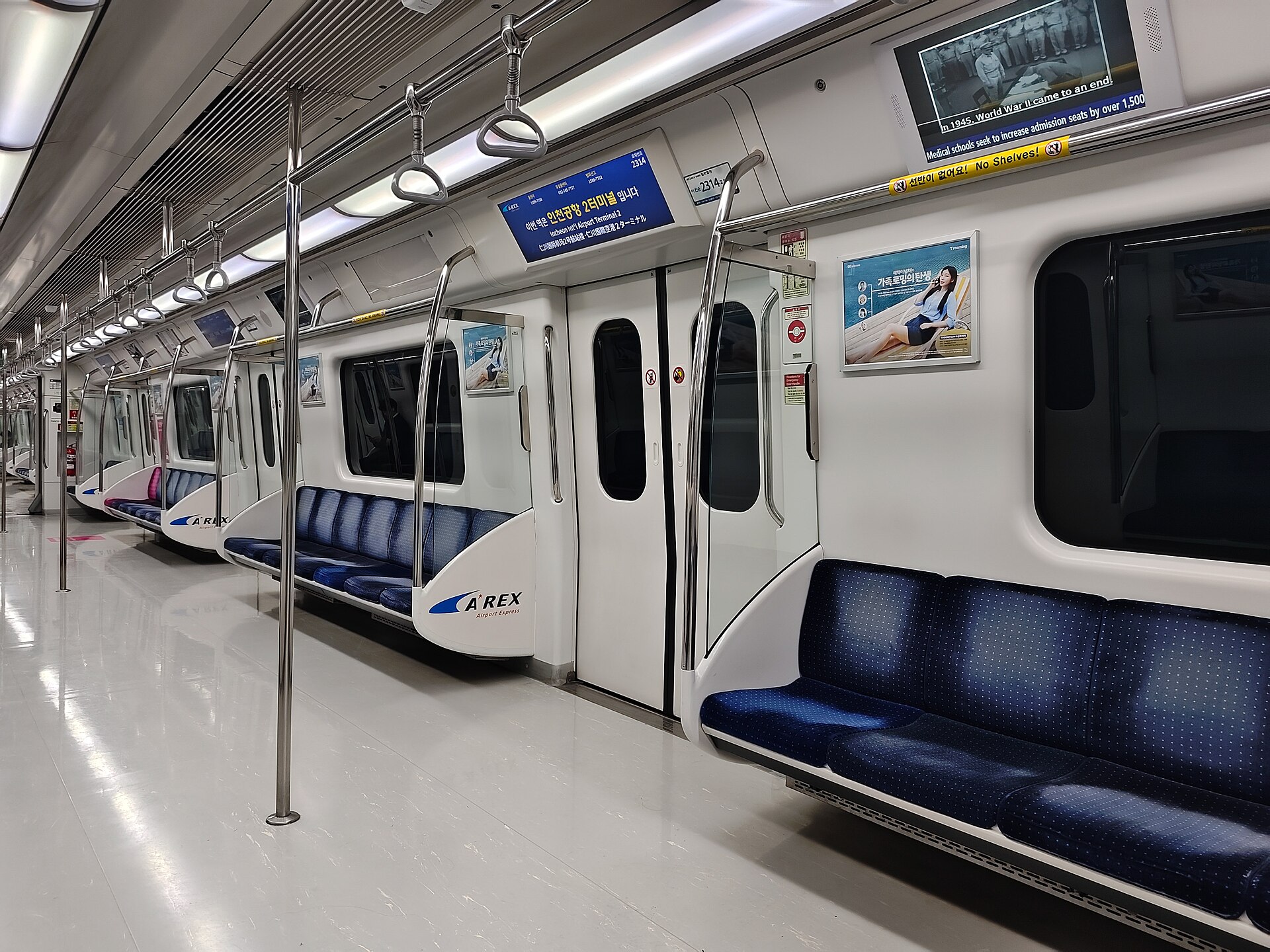 The interior of an AREX Airport Express train carriage with A'REX branding on the seats