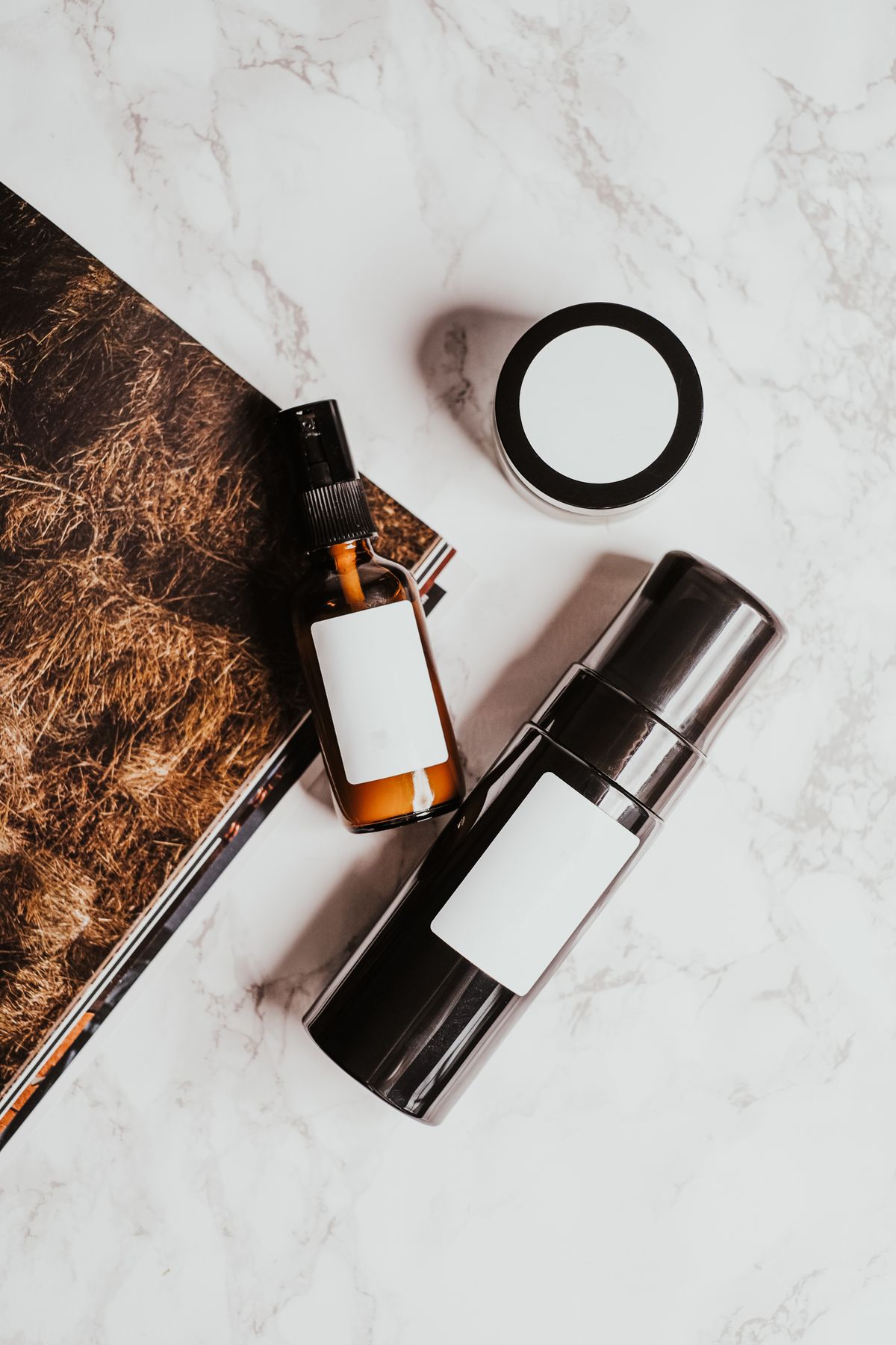 Korean skincare bottles and a jar arranged on a marble surface