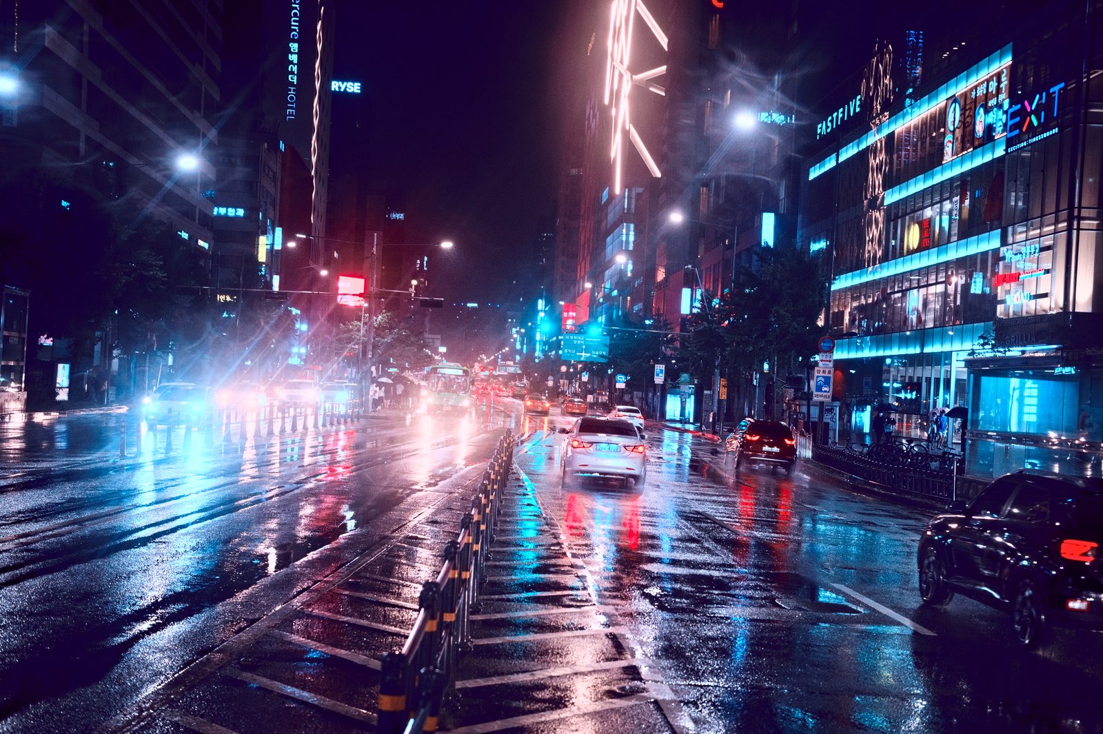 A rain-soaked Seoul street at night, neon signs and headlights reflecting on the wet road
