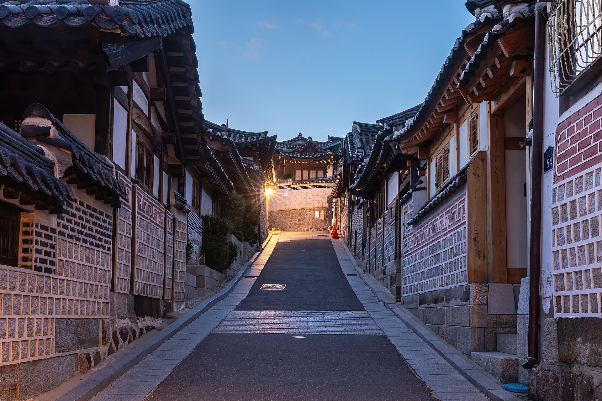A quiet tiled-roof hanok alley in Bukchon Hanok Village, Seoul, at blue hour